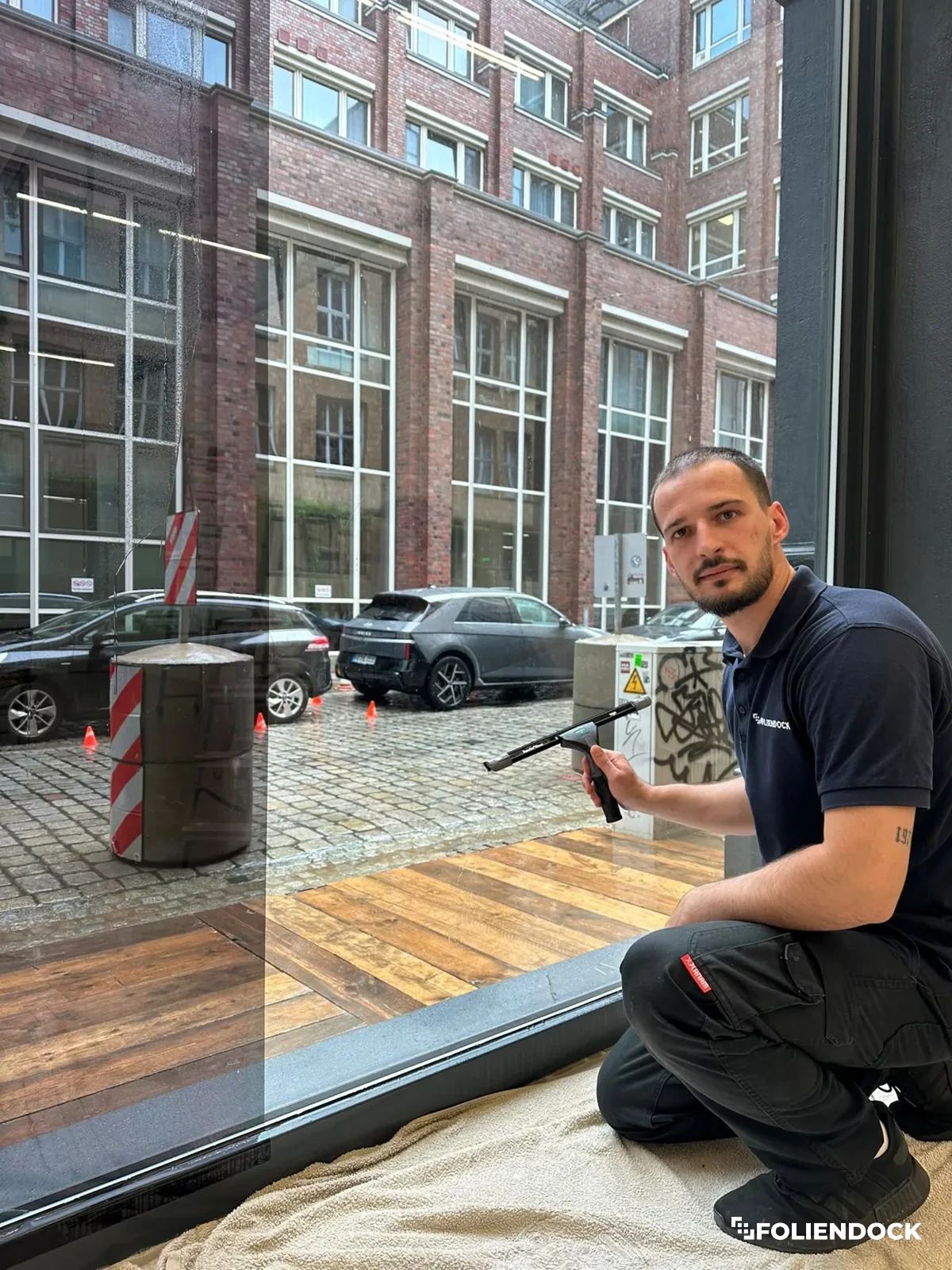 Monteur von FolienDock bei der Folierung eines großen Schaufensters
