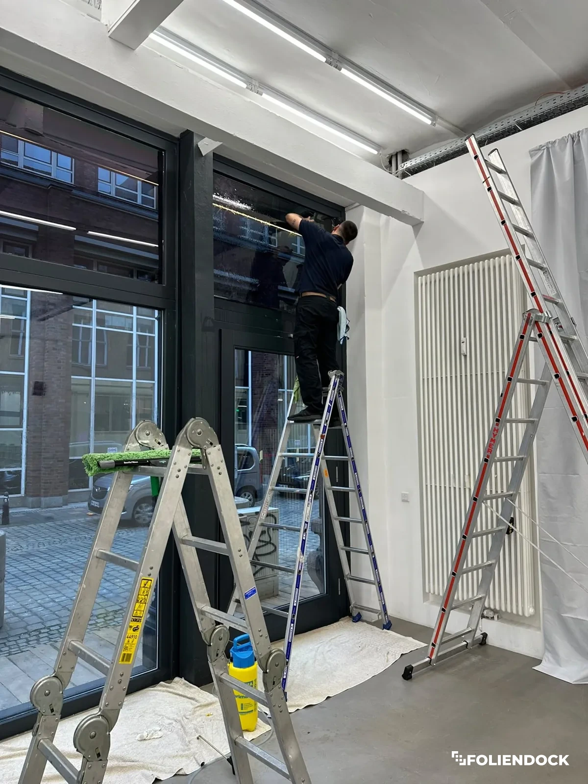 Montage einer Folie an einem großen Schaufenster